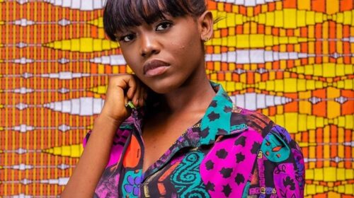 Gyakie standing infront of fabric design patterns