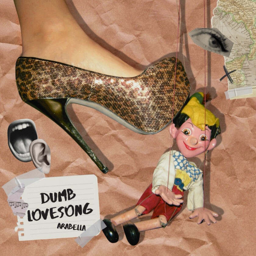 A woman holds a shoe with a man's foot on it. The image is related to the song 'Dumb lovesong' by Arabella.