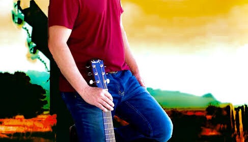 A man in a red shirt and blue jeans poses with an acoustic guitar against a rural backdrop with a windmill and sunset. An emblem above him reads "Todd Barrow.